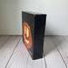 Photo of sideview of small square canvas painting of glowing jack o'lantern pumpkin with a black background