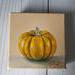 Photo of small square canvas painting of orange pumpkin with peach colored background