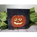 Photo of small square canvas painting of glowing jack o'lantern pumpkin with swirling eyes and a starry sky in the background