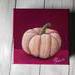 Photo of small square canvas painting of peach colored pumpkin with a raspberry pink background
