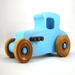 This handmade wooden toy car, modeled after a 1927 Ford T-Coupe, is hand-painted baby blue with black and metallic sapphire blue. The wheels are finished with nonmarring amber shellac.