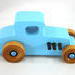 This handmade wooden toy car, modeled after a 1927 Ford T-Coupe, is hand-painted baby blue with black and metallic sapphire blue. The wheels are finished with nonmarring amber shellac.
