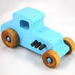 This handmade wooden toy car, modeled after a 1927 Ford T-Coupe, is hand-painted baby blue with black and metallic sapphire blue. The wheels are finished with nonmarring amber shellac.