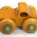 Handmade wooden toy monster truck, crafted in a toymaker's shop with traditional woodworking tools. Finished in amber shellac and metallic emerald green acrylic paint, this sturdy and durable toy is perfect for kids of all ages.