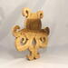 A handcrafted octopus puzzle made from wood. The puzzle is freestanding and can comfortably sit on a shelf, table, window sill, or door frame.