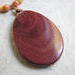 Pendant measures 2 1/2" x 1 3/4" with a hand wired bail of wood and brass.