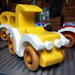 A handmade wooden toy car vintage style coupe painted nontoxic bright yellow and white with spoked wheels finished with nonmarring amber shellac from my  Bad Bobs Custom Motors Collection.