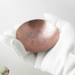 photo showing hand hammered copper trinket bowl 3 inch diameter in gloved hand