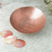 photo showing hand hammered copper trinket bowl 3 inch diameter shown with small oval tokens with "moody" and "neutral" stamped. Third token is left blank.