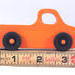 A handmade wooden toy pickup truck painted Pumpkin Orange and Black from my Play Pal Collection