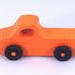 A handmade wooden toy pickup truck painted Pumpkin Orange and Black from my Play Pal Collection