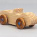 Handmade wooden toy car convertible sports coupe with a nontoxic satin polyethylene finish, amber shellac wheels, and metallic sapphire blue trim.