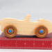 Handmade wooden toy car convertible sports coupe with a nontoxic satin polyethylene finish, amber shellac wheels, and metallic sapphire blue trim.