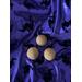 3 light tan balls of soap sitting on top of purple fabric that is decorated with black velvet witches riding brooms.