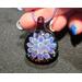 glass pendant-translucent lavender flower with bubbles on the tips of the petals on a red glass base.