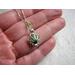 Genuine sea glass captured in a silver shell shaped locket and hung on a sterling silver chain necklace.