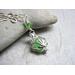 Genuine sea glass captured in a silver shell shaped locket and hung on a sterling silver chain necklace.