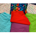 The "New" fabric is in the upper left it has a white background with different breeds of dogs drawn in black and bones, paws, and tennis balls in the colors aqua, red, purple, and green the same shades as the 4 solid color fabrics below. The upper middle fabric is Black Rainbow Paws it has a blended rainbow background and medium sized black paw prints. The fabric on the upper right is called White Rainbow Paws it has a white background and small gradient rainbow paws.