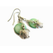 Sea turtle charm earrings set against a green shell disc bead in a soft green, the little turtle dangles freely on a short length of chain. 