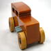 This handmade wooden toy car is based on a 1932 Ford Sedan Hot Rod. It is hand-finished with multiple coats of amber shellac and trimmed with black and grey acrylic paint.