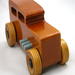 This handmade wooden toy car is based on a 1932 Ford Sedan Hot Rod. It is hand-finished with multiple coats of amber shellac and trimmed with black and grey acrylic paint.