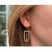 Shades of pink and gold dangle earrings on model