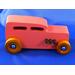 Handcrafted pink wooden hot rod '32 sedan toy car. Features black and metallic sapphire blue accents, and non-marking amber shellac wheels. Made to order for unique play or display.