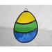 Stained glass Easter Egg on a neutral background, featuring yellow, green, and blue stripes