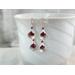 Garnet and rhodium-plated dangle calla lily earrings.