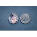 Charm next to a dime for size comparison on blue background.