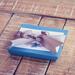 Turquoise blue jewelry gift box with gift tag and silver ribbon on natural wood background jewelry packaging example. 