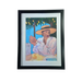 Framed art print of a woman wearing a hat sitting a a table
