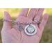 Lifestyle image of hand holding silver photo charm bracelet with dog photo, paw print, and forever in my heart charm.