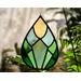 Spring Awakens Stained Glass Drop, featuring 12 pieces of hand-cut glass in spring greens and yellow, with plants & window in the background