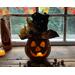 This shows the fall pumpkin gourd lit up with a battery-operated candle. Briar the pumpkin sits in front of a fall window display. 