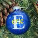 Blue Christmas Round 3" Ornament with a single white initial in the center with a name decal layered on top in yellow.  