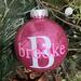 Pink Christmas Round 3" Ornament with a single white initial in the center with a name decal layered on top in soft pink.  