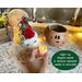 This image shows the Christmas elf, with his hat sitting next to him. A battery-operated candle is included in your purchase. 