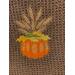 Pumpkin and stock of wheat on brown towel