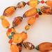 Orange glass and lucite beads.