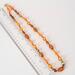 Long orange bead necklace with ruler.