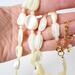 Mother of pearl beaded shell necklace in hand.