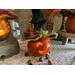 A  Halloween pumpkin that is lit up with a battery-operated candle. The gourd is decorating an entryway table for fall. 