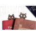 Pair of cat bookmarks peeking at each other from within two books.