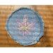 Light blue denim patch with lavender hemp leaf with green stitching in the center.