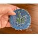 green stitched hemp leaf on blue denim round patch.