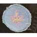 Light blue denim patch with lavender hemp leaf with green stitching in the center.