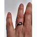 Sterling silver ring on a hand. It has a clear stone set in a handmade five prong setting.
