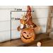 This is a fall Halloween witch decoration. It is 17 inches tall and 7 inches wide. It is a carved gourd with a handmade witch hat. T