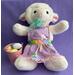Measurements: 15" top of head to feet - 14.5" diameter. White lamb with pink ears, aqua ribbon, purple Easter holiday pinafore, rainbow ribbon at waist, and pink buckle with eggs at her side.